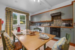 a kitchen with a wooden table with chairs and a tableablish at Keepers Cottage in Dunkeld