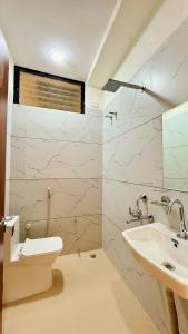 a bathroom with a toilet and a sink at Hotel Gurukripa in Harsola