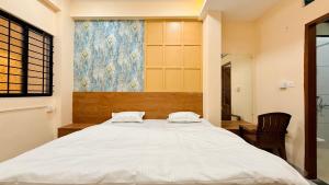 a bedroom with a large white bed and a window at Hotel Gurukripa in Harsola
