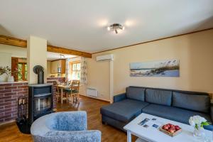 a living room with a couch and a fireplace at Heideröschen Park Heideröschen 7 in Zingst