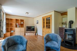 a living room with two chairs and a fireplace at Heideröschen Park Heideröschen 7 in Zingst