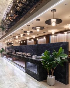a restaurant with a black counter with a buffet of food at Lords Inn Sanand in Chharodi