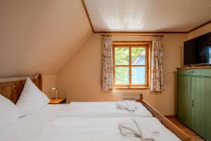 a bedroom with a bed with white sheets and a window at Heideröschen Park Heideröschen 7 in Zingst