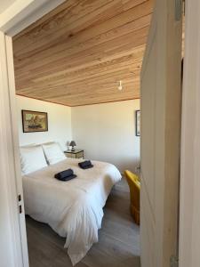 a bedroom with a large bed and a wooden ceiling at La Bournonville in Ault
