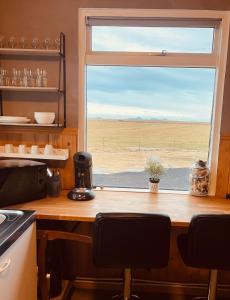 a kitchen with a window with a view of the desert at Vestra-Fíflholt cabin 3 in Hvolsvöllur