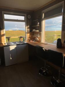 a kitchen with a sink and two windows with a view at Vestra-Fíflholt cabin 3 in Hvolsvöllur