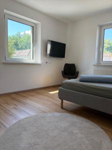 a room with two beds and a tv and a chair at Modern Apartment 1 Graf - New! in Grafenwöhr