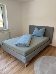 a bed with two blue pillows on it in a room at Modern Apartment 1 Graf - New! in Grafenwöhr