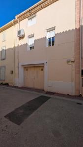 a building with two garage doors on a street at La maison boîte à gâteaux in Lapalme
