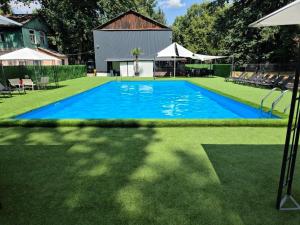 a large blue swimming pool on a grass field at Sunpark in Vadul lui Vodă