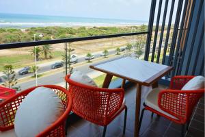 a balcony with a table and chairs and a view of the beach at Hotel Deauville El jadida in El Jadida