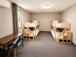 a room with three bunk beds and a desk at White Chalet Niseko in Niseko