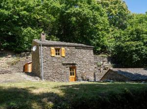 a small stone house with yellow doors and windows at Le gîte du comte 2/3 personnes in Saint-Germain-de-Calberte