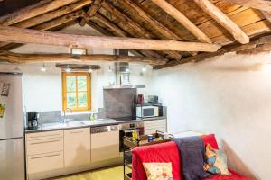 a kitchen with a refrigerator and a stove top oven at Le gîte du comte 2/3 personnes in Saint-Germain-de-Calberte