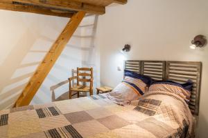 a bedroom with a bed with a wooden headboard and a chair at Le gîte du comte 2/3 personnes in Saint-Germain-de-Calberte