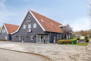 a large black building with a red roof at Steam & Dream - Hottub & Sauna Retreat - Free WiFi - Full Privacy - Luxury Experience in Heinkensand