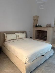 a large bed in a room with a fireplace at Gocce su Pietra in Sannicandro di Bari