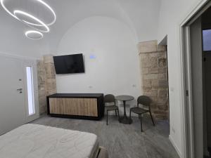 a bedroom with a bed and a table and chairs at Gocce su Pietra in Sannicandro di Bari