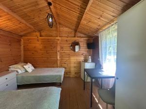 a bedroom with a bed and a desk in a cabin at Poilsiavietė Vita in Šventoji