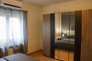 a bedroom with a glass closet with a bed at Paola Apartment in Pula +33 photos