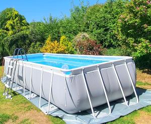 a large white pool sitting in the grass at Maison des Roses in Béalencourt