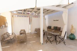 a room with chairs and tables and a couch at Palazzo Sospiri in Bisceglie