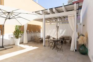 a patio with a table and chairs and an umbrella at Palazzo Sospiri in Bisceglie