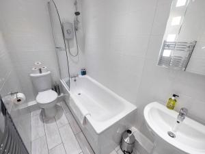 a white bathroom with a toilet and a sink at 93 King Street in Broughty Ferry +15 photos