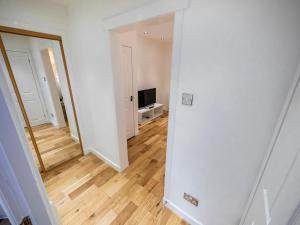 an empty living room with a mirror and a television at 93 King Street in Broughty Ferry