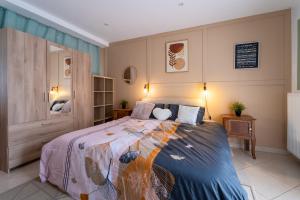 a bedroom with a large bed with a colorful blanket at La Maison du Bonheur - Appartements & Chambres à Gisors in Gisors