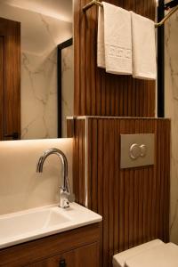 a bathroom with a sink and a toilet and towels at Palmiye Suite Hotel Bakirkoy City Center in Istanbul