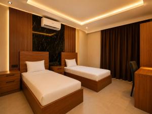 a hotel room with two beds and a desk at Palmiye Suite Hotel Bakirkoy City Center in Istanbul