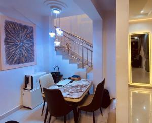 a dining room with a table and chairs and a staircase at Sheylex Apartments in Idogwari +13 photos