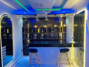 a bar with blue lights in a room at Sheylex Apartments in Idogwari