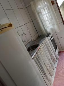 a dirty kitchen with a sink and a window at Refúgio Charmoso 1 in Volta Redonda