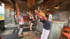 a man and three girls doing a yoga pose in a bar at Joni Ubud Hostel in Ubud +85 photos