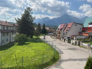 a street in a town with houses and mountains at Homestay Renata in Nová Lesná