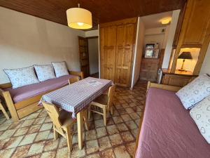 a living room with a table and a couch at Studio Ban rouge, Chez Francine in Notre-Dame-de-Bellecombe +22 photos