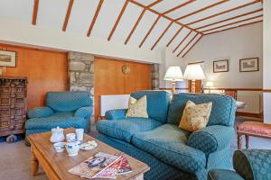 a living room with two blue chairs and a table at Jock Scott Cottage in Dunkeld