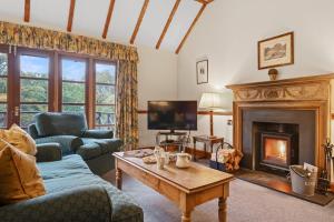 a living room with a couch and a fireplace at Jock Scott Cottage in Dunkeld