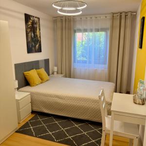 a bedroom with a bed with yellow pillows and a window at Theo in Poznań