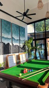 a pool table in front of a room with windows at Athiri Residence Dhiffushi in Dhiffushi