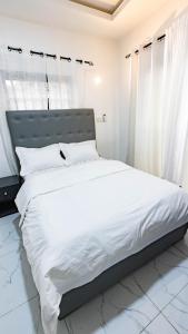 a bedroom with a large bed with white sheets at Moonlight heaven suites in Limbe