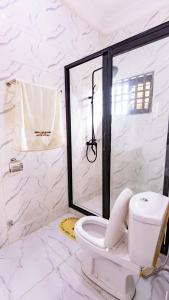 a white bathroom with a toilet and a shower at Moonlight heaven suites in Limbe +35 photos