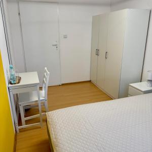 a bedroom with a bed and a table and a desk at Theo in Poznań