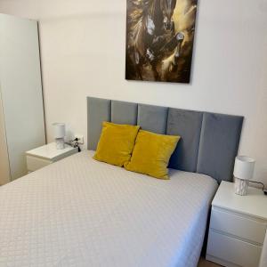 a bedroom with a bed with two yellow pillows at Theo in Poznań