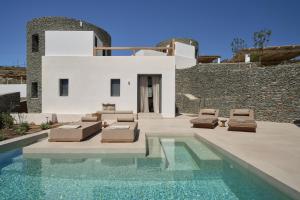 a villa with a swimming pool in front of a house at AOTO Villas in Kithnos