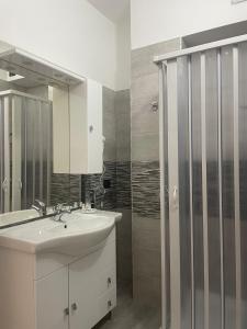 a bathroom with a sink and a shower at Sole & Mare Rooms Briatico in Briatico +41 photos