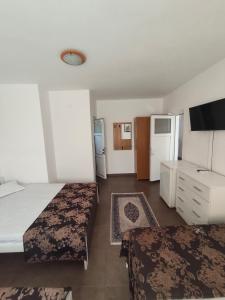 a hotel room with two beds and a tv at vila CALIL in Eforie Nord