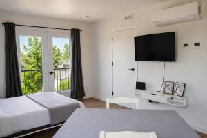 a hotel room with a bed and a flat screen tv at Appart'hôtel Vivéo - Par Aneyro in Quebec City